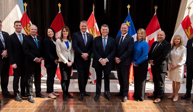 Premier King and new Cabinet members stand in front of PEI and Canada flags