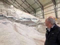 Transportation and Infrastructure Minister Ernie Hudson looking at a large pile of salt in a salt dome at the Queens County Highway Depot.